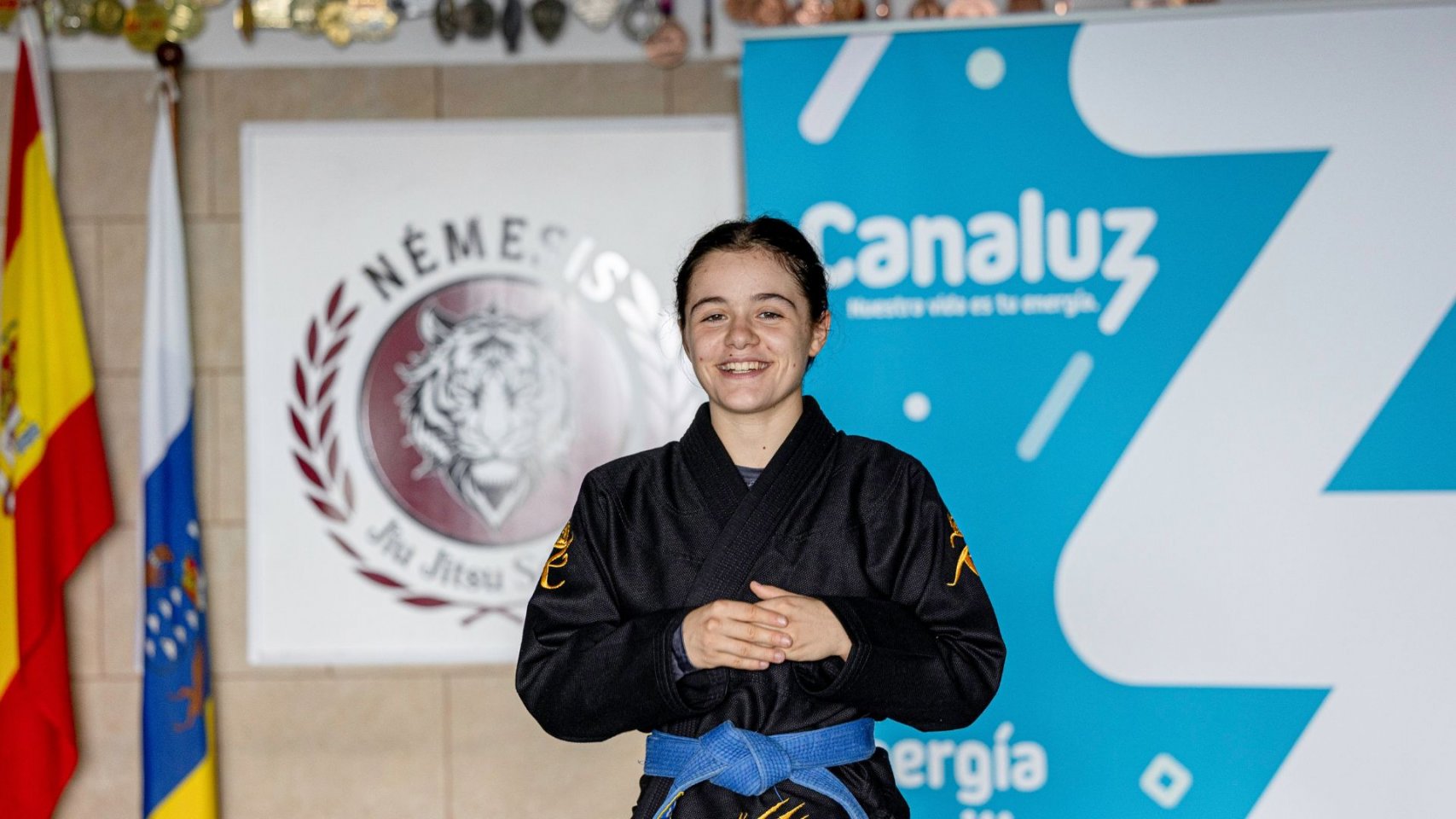 Foto Marcos de Rada: La medallista mundial, Iris García, joven promesa del Grappling español, posa en su gimnasio junto a la marca Canaluz y el escudo del Team Némesis Foto Marcos de Rada: La medallista mundial, Iris García, joven promesa del Grappling español, posa en su gimnasio junto a la marca Canaluz y el escudo del Team Némesis